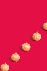 Mandarins in the form of a Christmas tree toy iaolated on red background with copy space. Minimalistic christmas concept