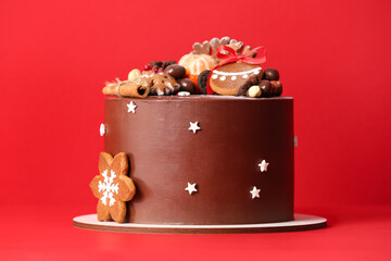 Stand with tasty Christmas chocolate cake on red background