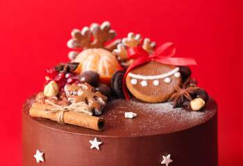 Tasty Christmas chocolate cake on red background, closeup