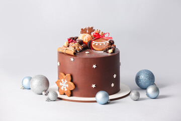 Stand with tasty Christmas chocolate cake and balls on light background - Powered by Adobe
