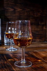 Glasses of strong scotch single malt whisky served on dark wooden table in old pub