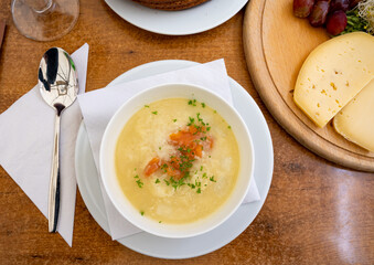 Seasonal dish, white asparagus cream soup with smoked salmon fish