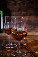 Glasses of strong scotch single malt whisky served on dark wooden table in old pub