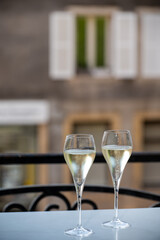 Romantic party with two glasses of white cold champagne and view on old street in French village