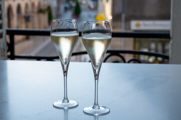 Romantic party with two glasses of white cold champagne and view on old street in French village
