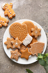 Plate with sweet Christmas gingerbread cookies on grey background