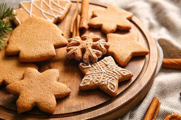 Wooden board with sweet Christmas gingerbread cookies on table, closeup
