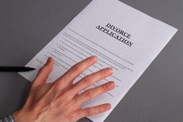 A hand hovering over divorce papers