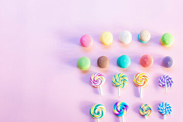 Rainbow sweets and macaron on a pink background in the morning when sunlight shines through the window glass.