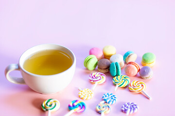 Sweets and tea on the pink table look delicious.
