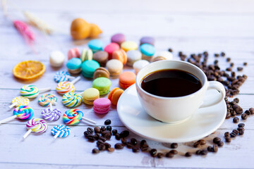 Drink hot black coffee in a white cup with colorful sweets in winter to keep warm.
