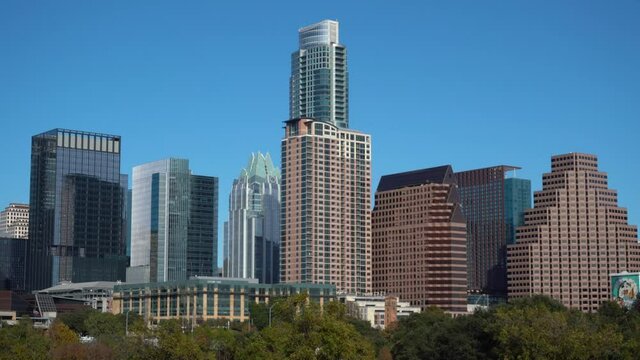 Zoom in shot of modern skyline with skyscrapers of Austin against blue sky in summer - Texas,USA
