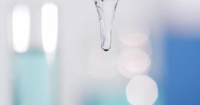 A drop flowing very slowly from a pipette, close shot