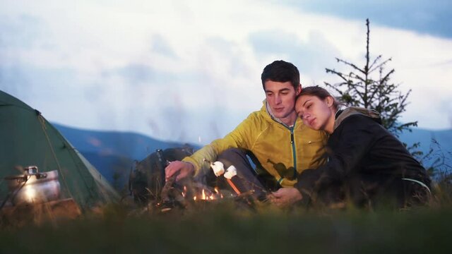 Preparing marshmallows from campfire. Majestic Carpathian Mountains. Beautiful landscape of untouched nature