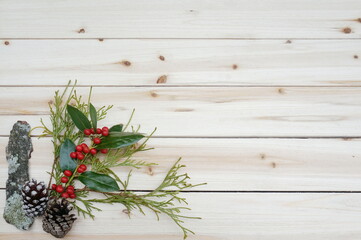 Arbor Vitae Green Bittersweet with Red Berries Mossy Bark and Pinecone on Lower Right Corner of Natural Wood Panels with Room for Text