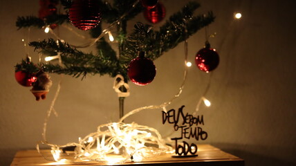 Christmas. Christmas ornaments. Christmas baubles with lighting and red polka dots hanging on the Christmas tree. Message: God is good all the time.