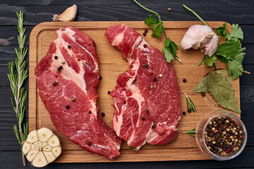 meat steak wooden board and spices ingredients top view