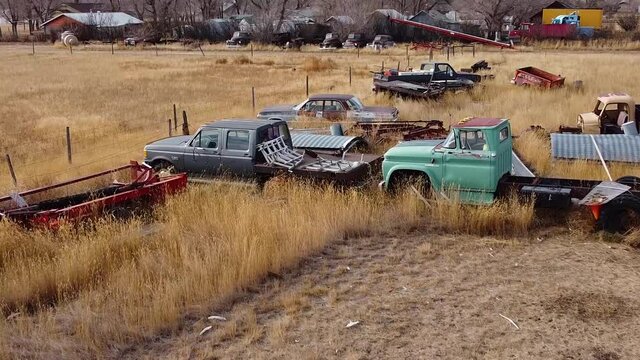 Old rusty cars and trucks in a over grown field in the country near Alberta Canada.