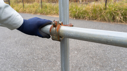 鉄パイプの手すり｜クランプのサビを確認する作業員