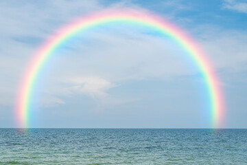 rainbow in the blue sky and tropical ocean background