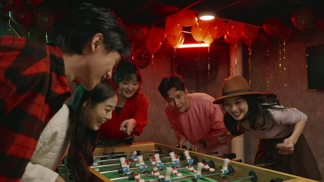 Happy young friends playing table football,4K