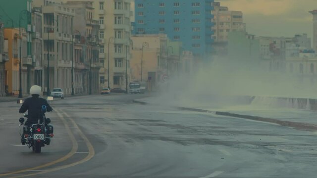 motorcycle driving on the malecon with ocean waves, Havana, Cuba
