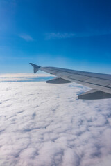 View from the airplane window at a beautiful cloudy sky and the airplane wing
