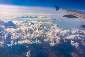 Fototapeta premium View from the airplane window at a beautiful cloudy sky and the airplane wing