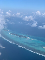 Aerial view of the Maldives in the turquoise water of the Indian Ocean from the porthole of a local airlines plane
