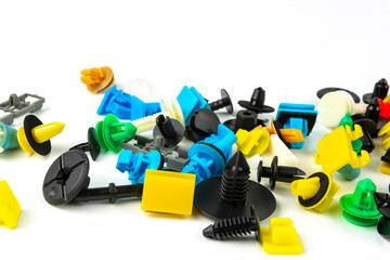 Fototapeta premium Close-up shot of plastic colored clips for the car.Abstract background. Panel plastic rivets isolated on white background. Auto plastic clasps. Insulated clip or automatic plastic clasp