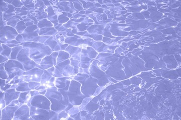 Very peri color of the year 2022. Trendy concept. Swimming pool bottom caustics ripple and flow with waves background.