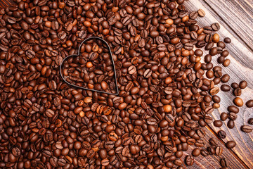 Empty Heart shape made inside of coffee beans background. Flat lay. Symbol of Love to coffee. Vertical wooden wallpaper