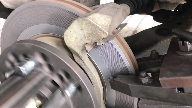 Mechanic repairing brake use lathe tool polishing disc brakes of cars. ,rebuild disc brake surface.