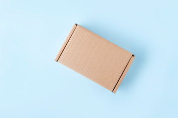 Blank cardboard box package on blue background. Craft paper box for gift. Shipping eco package....