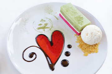 Red heart on dessert plate with cake and vanilla icecream.