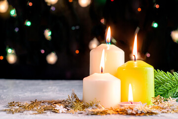 black Christmas background with colorful lights burning candles and decorative snowflakes in the foreground