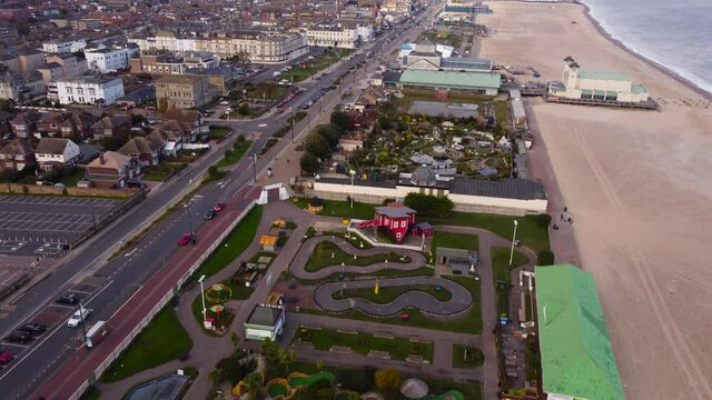 Aerial: Merrivale Model Village between urban city and sea beach at Great Yarmouth, Norfolk - drone establishing shot