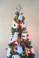 Holiday Christmas tree decorated with toilet paper, rubber gloves and face masks in honor of the...