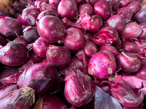 Purple onions stacked on the counter in the market