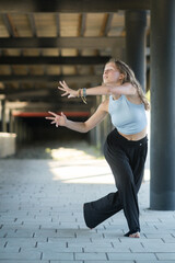 The girl dances beautifully under the bridge