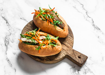 Pork Banh Mi hot dogs on cutting board on a light background, top view