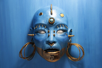 Face sculpture, fantastic creature. Female face, painted in blue and gold. Golden metallic...