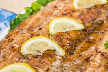 Grilled red fish garnished with green parsley and yellow lemon slices