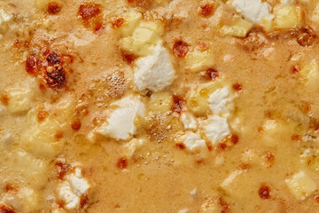 Closeup of browned cheese crust on baked pizza quattro formaggi