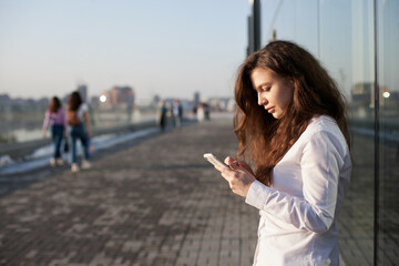 Fototapeta premium woman with mobile phone using technology for texting or social media in the city