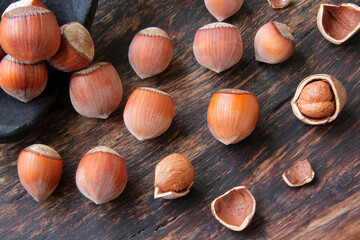 walnut, hazelnuts in a black spoon on a wooden background.