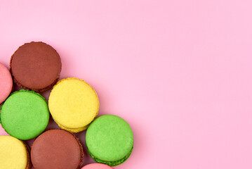 Heap of bright cookies on a pink background, copy space.