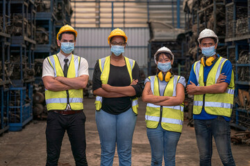 Portrait of warehouse worker. Group of factory industry worker working with face mask to prevent virus spreading during job reopening period.