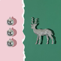 Christmas creative layout with silver reindeer and disco balls  decoration on dark green and pastel...