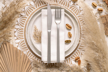 Fototapeta premium Boho Wedding Table place near dried plants, palm leaves and pampas grass